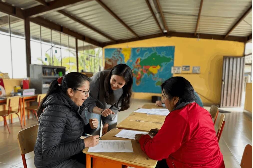 A teacher helping older students 